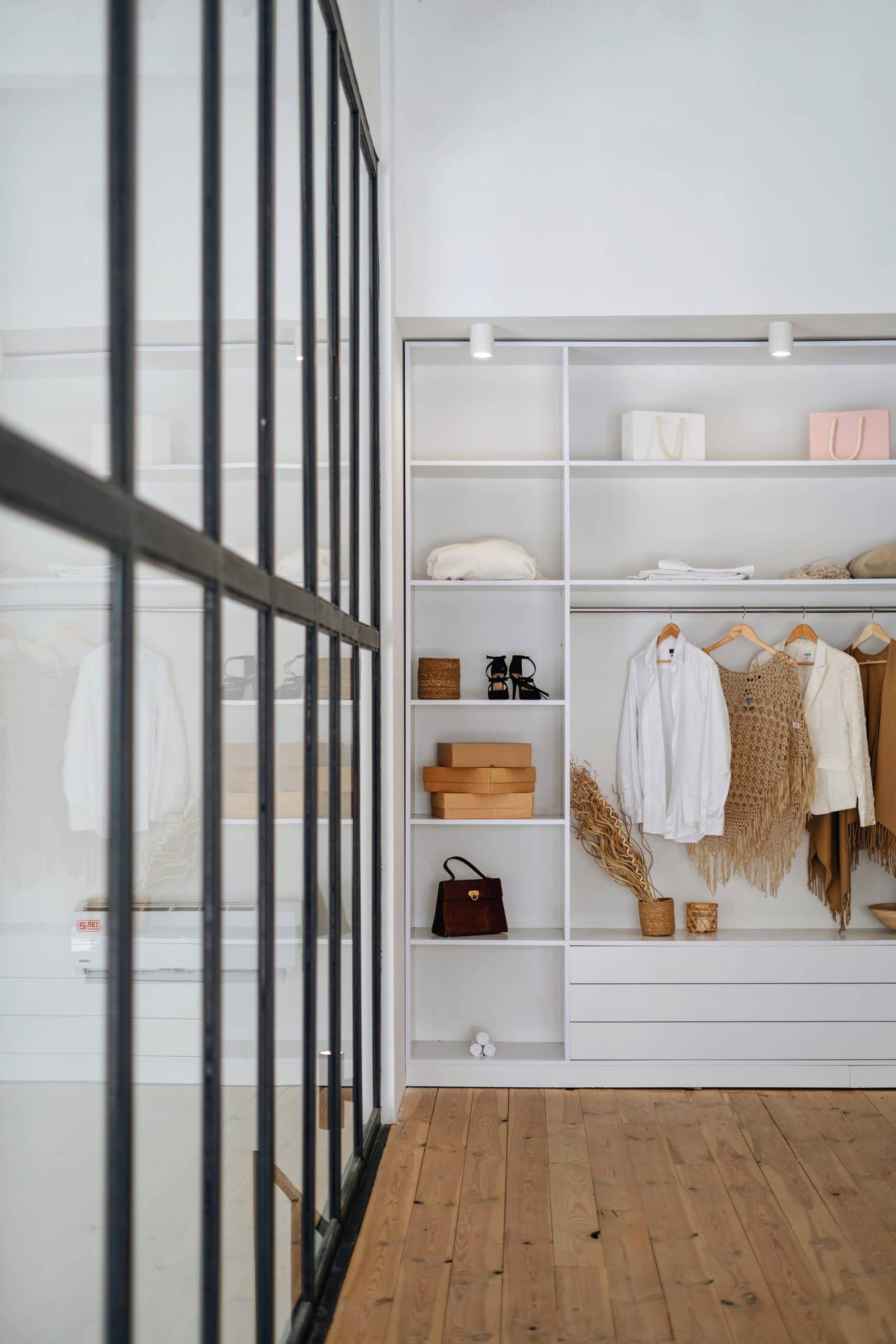 organised white wardrobe with clothes hanging